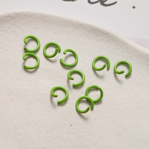 Dettaglio di nove anellini aperti 8mm verde brillante su vassoio per creazione gioielli
