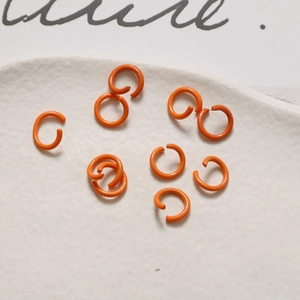 Dettaglio di anellini aperti arancioni da 8 mm per gioielli fai-da-te e portachiavi
