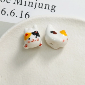 Macro shot of handmade calico cat ceramic beads with glossy glaze for DIY jewelry making