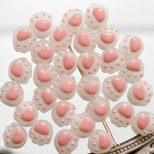 Detalle de cuentas de vidrio con forma de pata de gato rosa para joyería artesanal DIY