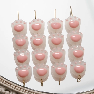 Primer plano de cuentas de resina de pata de gato rosa para joyería con reflejo espejo