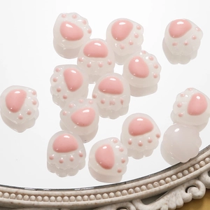 Detalle de cuentas de resina con forma de pata de gato rosa para creación de joyas DIY