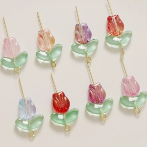 Macro shot of colorful glass tulip charms with gold pins for DIY jewelry making