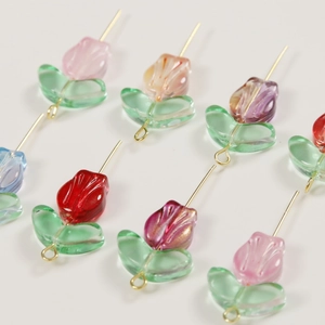 Close-up of translucent glass tulip flower beads with gold glitter for DIY jewelry making