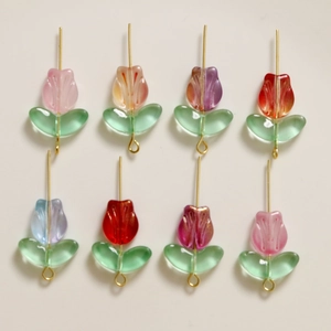 Detailed view of colorful frosted glass tulip charms with gold pins for DIY jewelry making