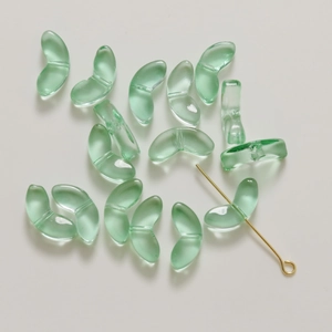 Macro detail of translucent light green glass beads with double holes for DIY jewelry
