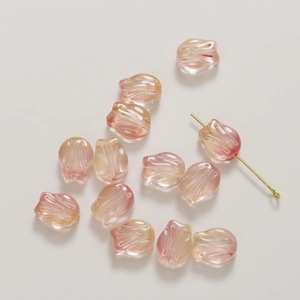 Macro view of translucent tulip glass beads for DIY jewelry making with gold-tone pin detail