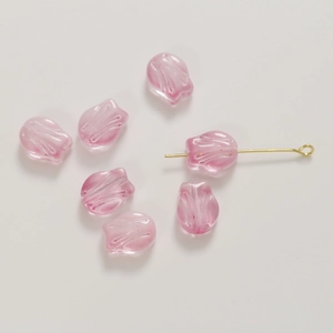 Macro shot of pink glass tulip beads with golden pins for DIY handmade jewelry crafts
