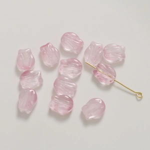 Close-up of pink tulip glass beads with gold powder texture for DIY jewelry making