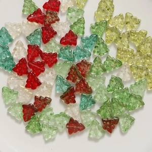 Macro shot of 3D glass Christmas tree beads for DIY jewelry with glitter and textured finish