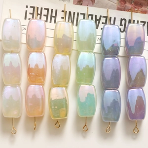 Detail of colorful iridescent rectangular resin beads for DIY jewelry with gold metal pins
