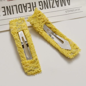 Close-up of yellow lace crochet snap hair clips with delicate floral hollow patterns