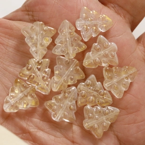 Macro view of champagne gold 3D glass Christmas tree beads with drill holes for DIY jewelry