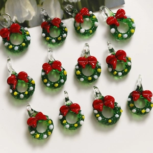 Detailed close-up of handmade glass Christmas wreath charms with red bows and colorful dots