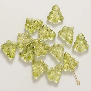 Macro detail of a green glass Christmas tree bead with gold glitter for DIY jewelry