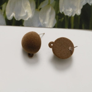 Detail of brown flocked ball stud earrings with metal pins and textured plush surface