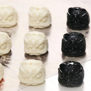 Dettaglio macro di perle a forma di leone danzante bianco e nero con motivi intagliati