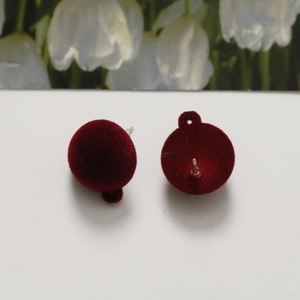 Macro view of burgundy flocked round stud earrings with hanging loop for DIY jewelry making