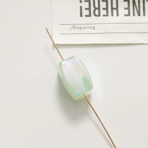 Macro shot of light green rectangular mermaid glitter bead with vertical hole for DIY