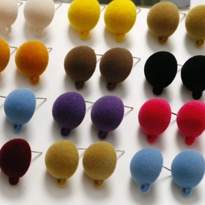 Macro shot of colorful flocked round stud earrings in various shades on display