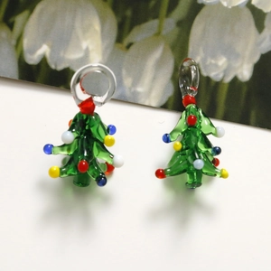 Close-up of green glass Christmas tree pendants with colorful beads for jewelry making