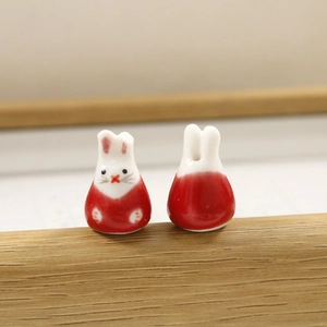 Gedetailleerde macro-opname van handbeschilderde keramische konijnkralen met rood glazuur