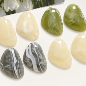 Close-up of marble pattern resin patches in olive and beige for DIY crafts making