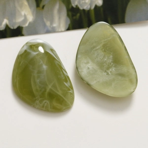 Detailed view of green marble pattern resin drops for DIY jewelry and hair accessories