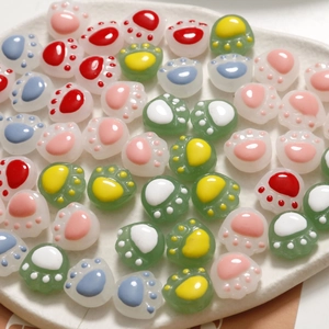 DIY colorful cat paw glass beads for jewelry making in a white ceramic dish