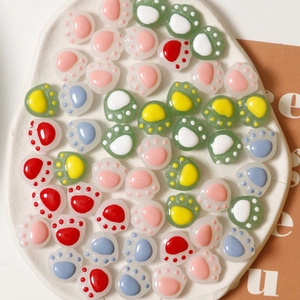 Macro view of colorful resin cat paw charms for DIY jewelry and hair accessories
