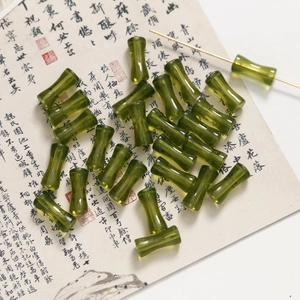 Dettaglio di perline in acrilico verde smeraldo a forma di bambù per gioielli fai da te