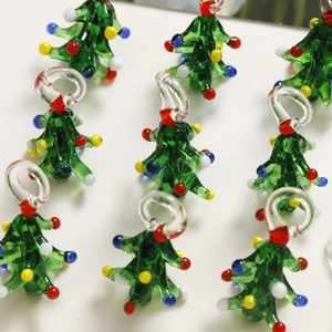 Macro shot of 3D green glass Christmas tree pendants with colorful beads for DIY jewelry