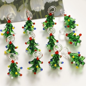 Handcrafted green glass Christmas tree pendants with colorful glass dots on white background