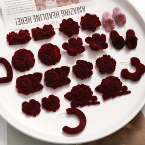Macro view of French vintage burgundy velvet rose and daisy floral DIY earring materials