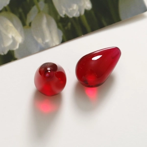 Dettaglio macro di due perle in resina rosso scuro traslucido a forma di goccia d'acqua