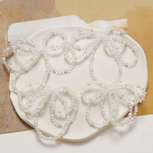 Detail of white imitation pearls and crystal beads on a ceramic tray for DIY jewelry