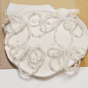 Detail of multi-layer beaded hair accessory with white pearls and clear crystal beads