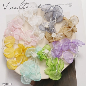Macro detail of layered organza flower petals with elegant beaded chain accents
