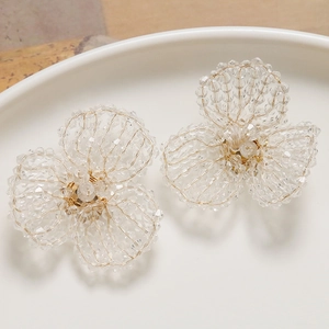 Detail of handcrafted woven crystal bead flower earrings with gold wire accents