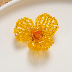 Macro view of handmade yellow crystal beaded flower accessory for DIY jewelry and hair clips