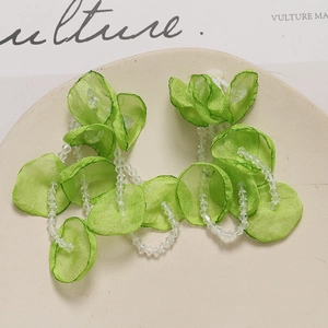Detailed macro view of light green tulle flower pendant with hanging crystal bead tassels