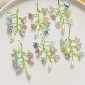 Vue détaillée de pendentifs muguet faits main dans un plateau en céramique blanc