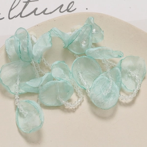 Close-up of mint green organza flower petal pendant with translucent crystal beads