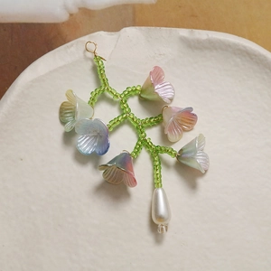 Gros plan d'un pendentif muguet en perles colorées avec une finition de perle d'eau douce