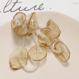 Detail of champagne mesh flower petals with crystal beads on a ceramic tray