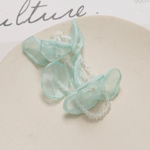 Detailed view of mint green tulle flower hair accessory with delicate crystal bead tassels