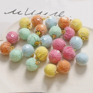 Close-up of colorful sequined round pendant charms with gold rings for DIY jewelry making