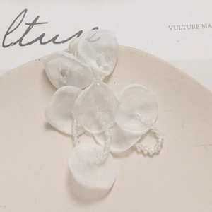 Macro detail of handmade white tulle flower petals with crystal beads for DIY jewelry