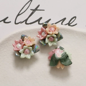 Macro-opname van gekleurde keramische rozenkralen met groene bladeren voor DIY-sieraden