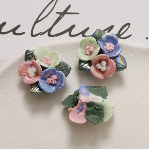Gedetailleerde close-up van handgemaakte iriserende keramische rozen voor sieraden
